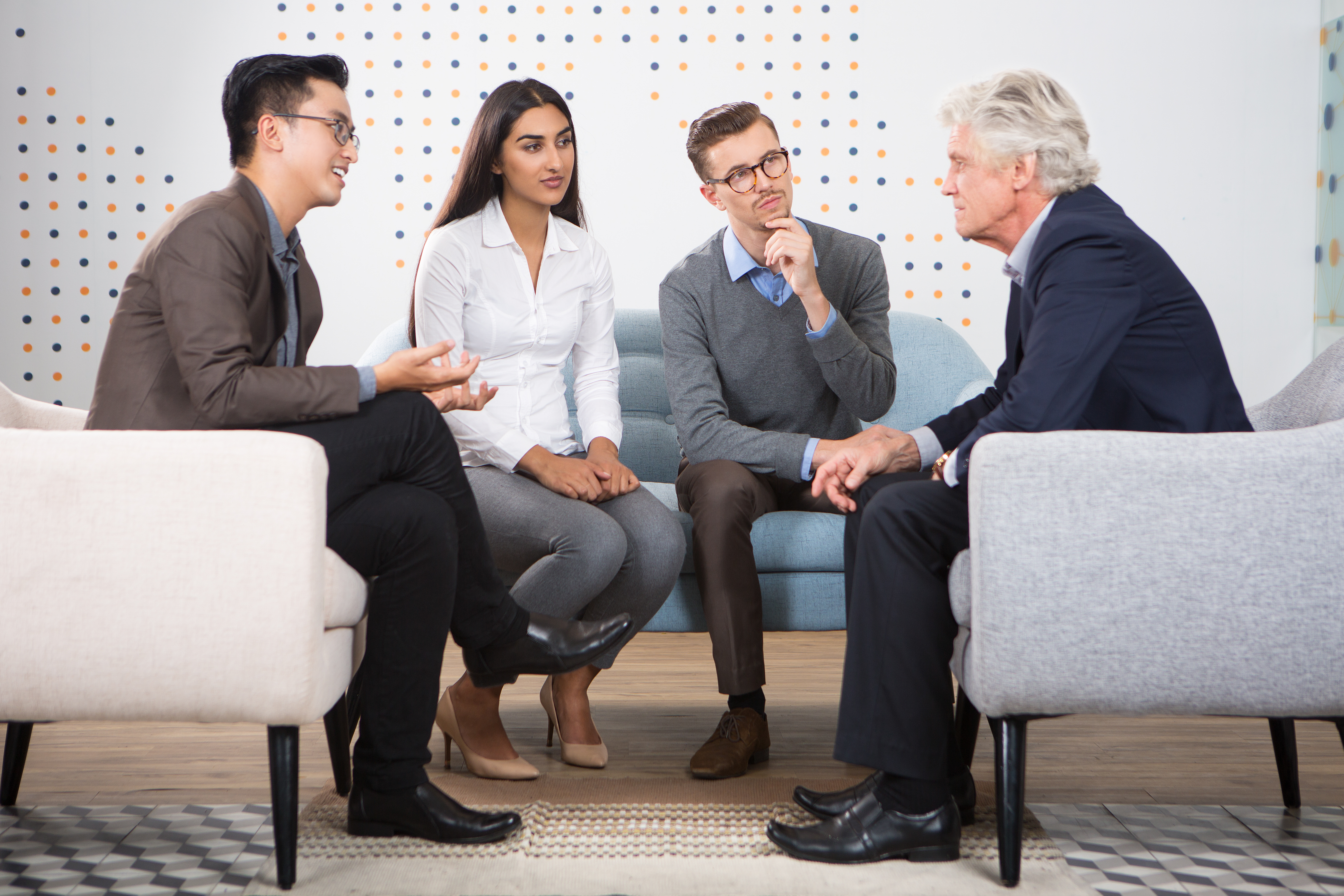 Young people talking senior business leader